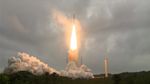 Photo of Ariane 5 rocket carrying Webb telescope launching into a cloudy sky.