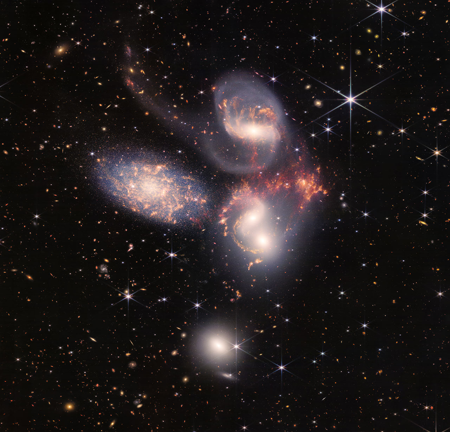Colorful image of the near- and mid-infrared light of a group of galaxies, with hundreds of background galaxies and numerous foreground stars.
