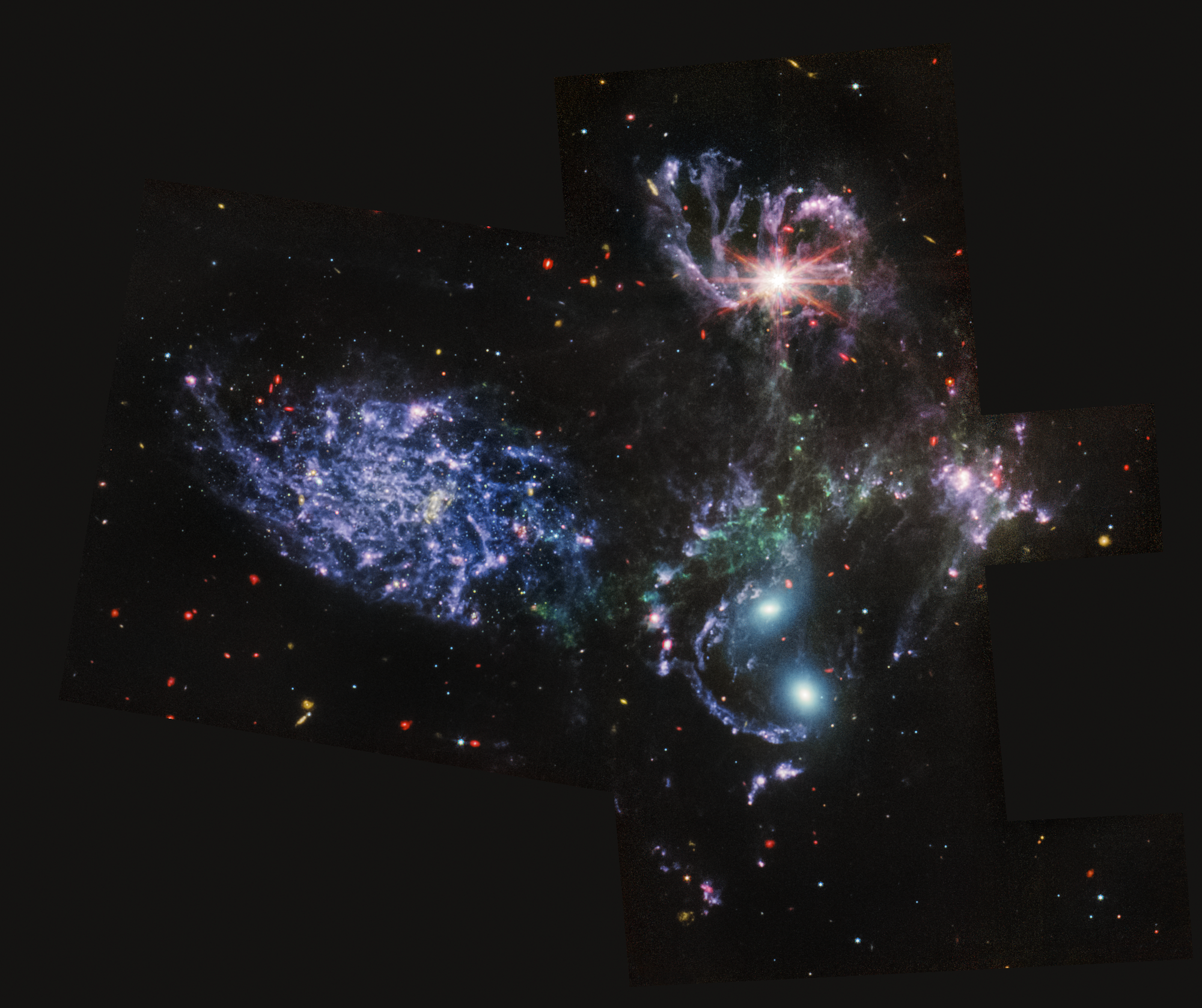 Colorful image of the mid-infrared light of a group of galaxies, with many background galaxies.