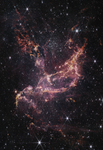 A star cluster within a nebula. The center of the image contains arcs of orange and pink gas that form a boat-like shape. One end of these arcs points to the top right of the image, while the other end points toward the bottom left. Another plume of orange and pink gas expands from the center to the top left of the image. To the right of this plume is a large cluster of white stars. There are more of these white stars and a few galaxies of different sizes spread throughout the image.