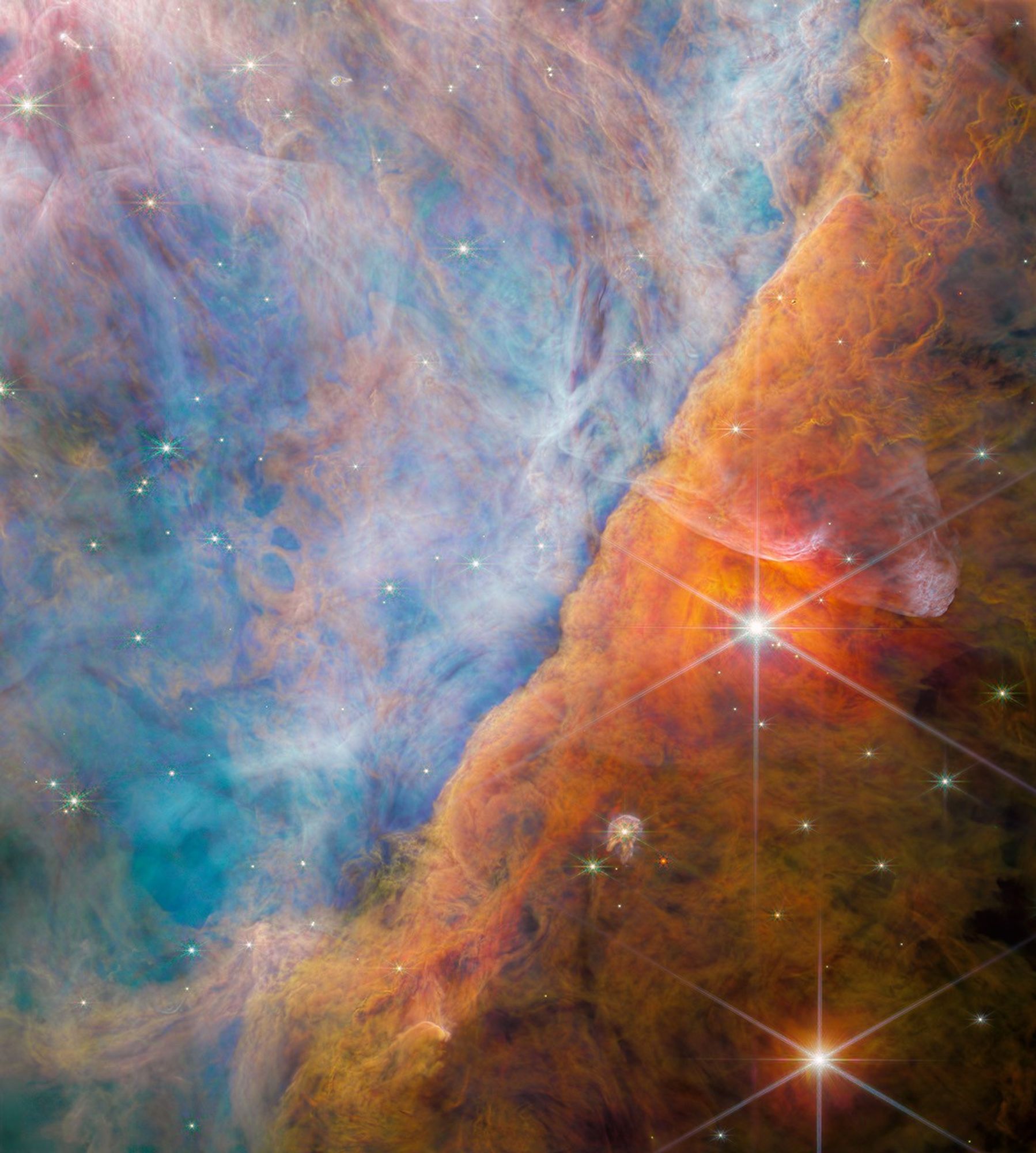A billowy nebula colored mostly blue on the left side and orange-brown on the right side.
