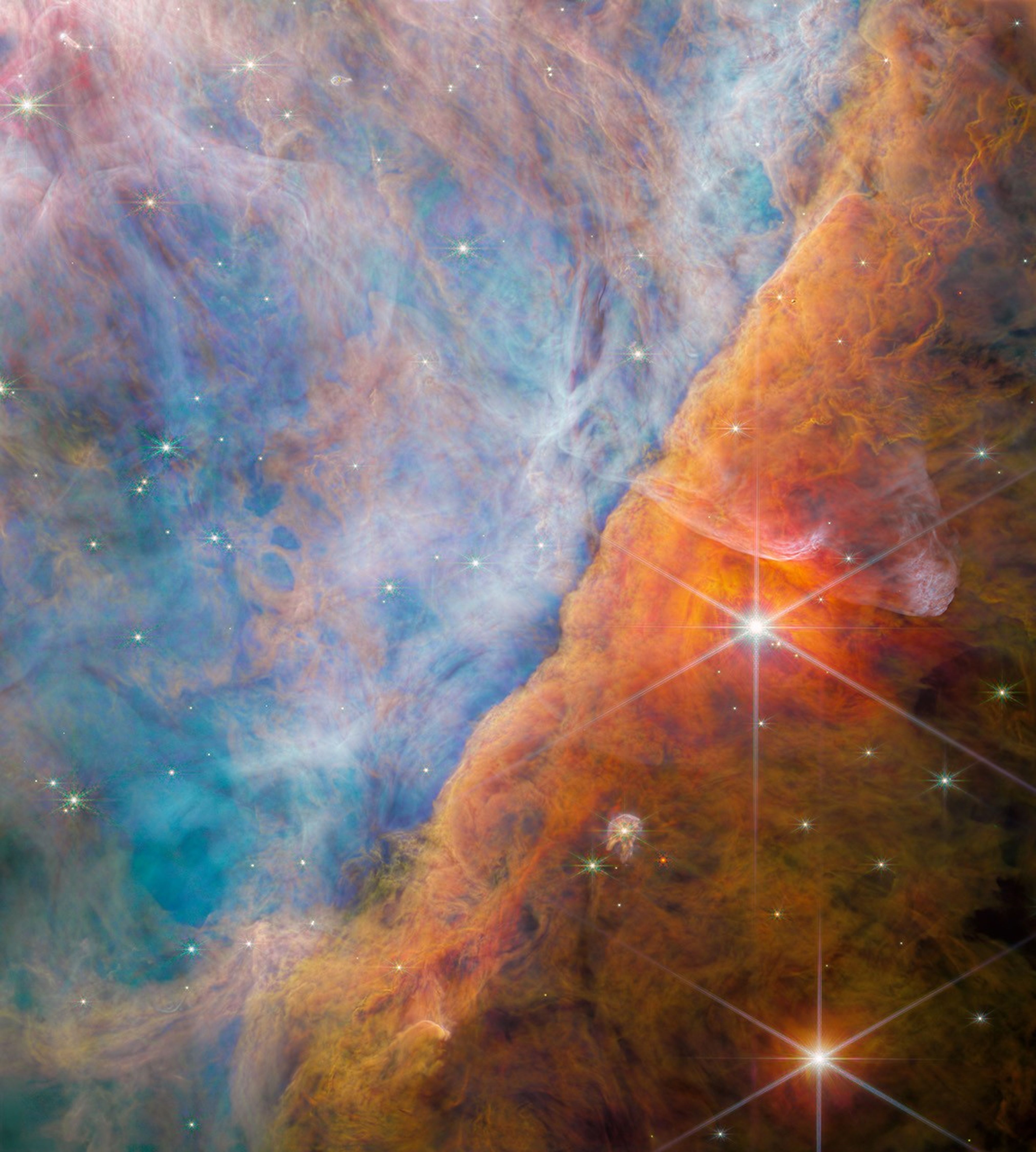 A billowy nebula colored mostly blue on the left side and orange-brown on the right side.