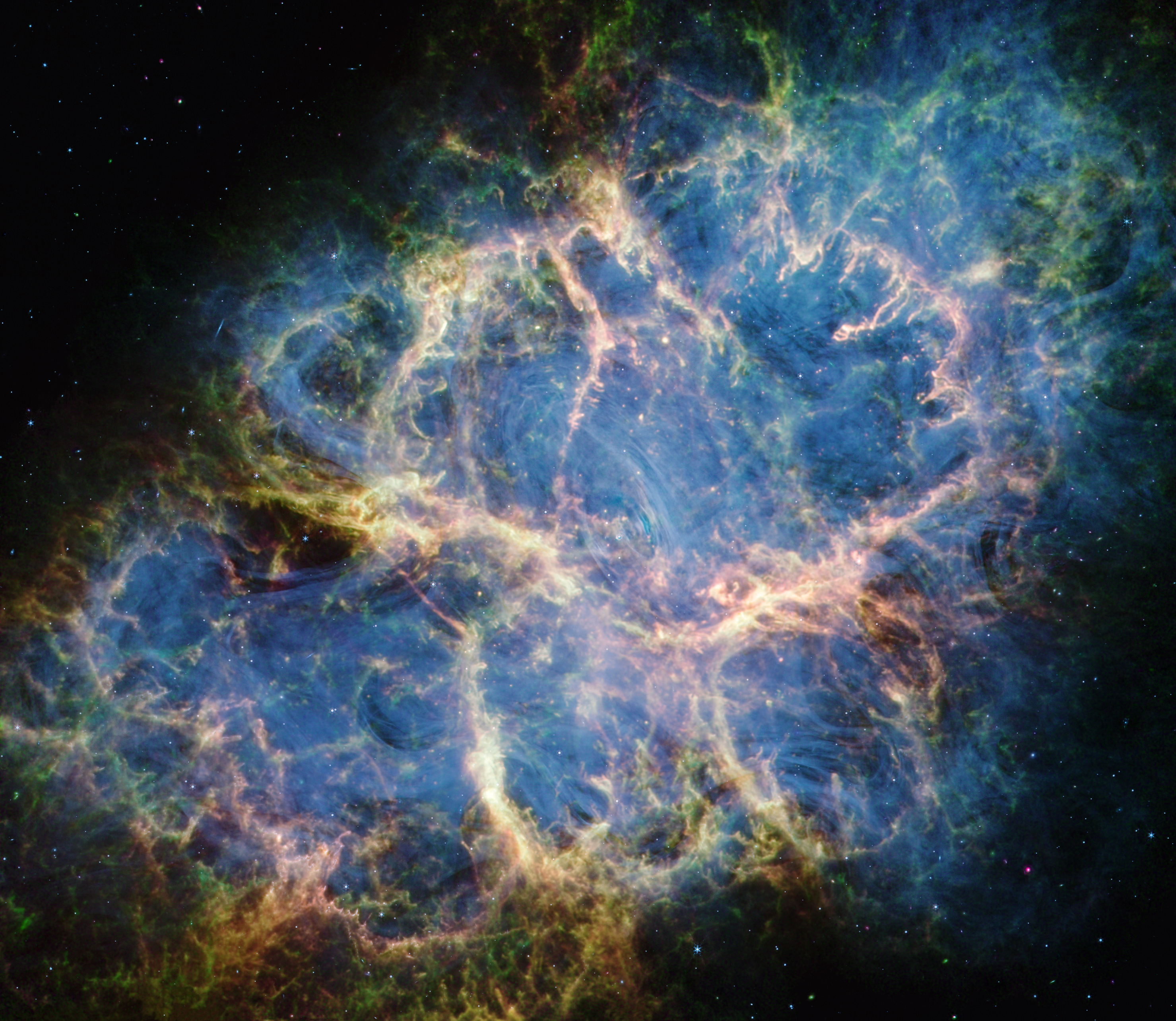 The Crab Nebula. A multicolored oval with complex structure extends from lower left to upper right against a black background.