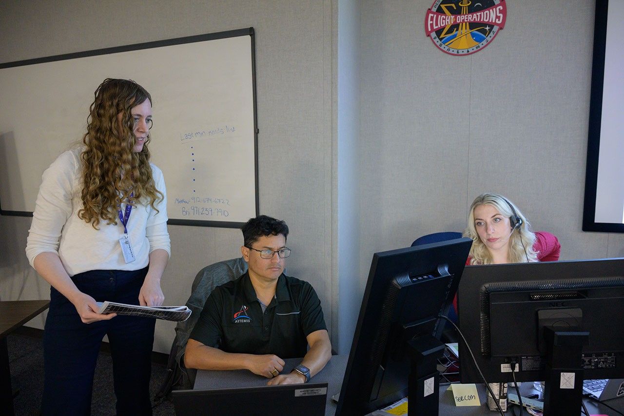 Artemis III Geology Team lead Dr. Brett Denevi of the Johns Hopkins University Applied Physics Laboratory in Laurel, Maryland, left, Artemis III Geology Team member, Dr. Jose Hurtado, University of Texas at El Paso, and simulation co-lead, Bri Sparks, work together during the Artemis III Virtual Reality Mini-Simulation at NASA’s Johnson Space Center in Houston. The simulation was a test of using VR as a training method for flight controllers and science teams’ collaboration on science-focused traverses on the lunar surface.