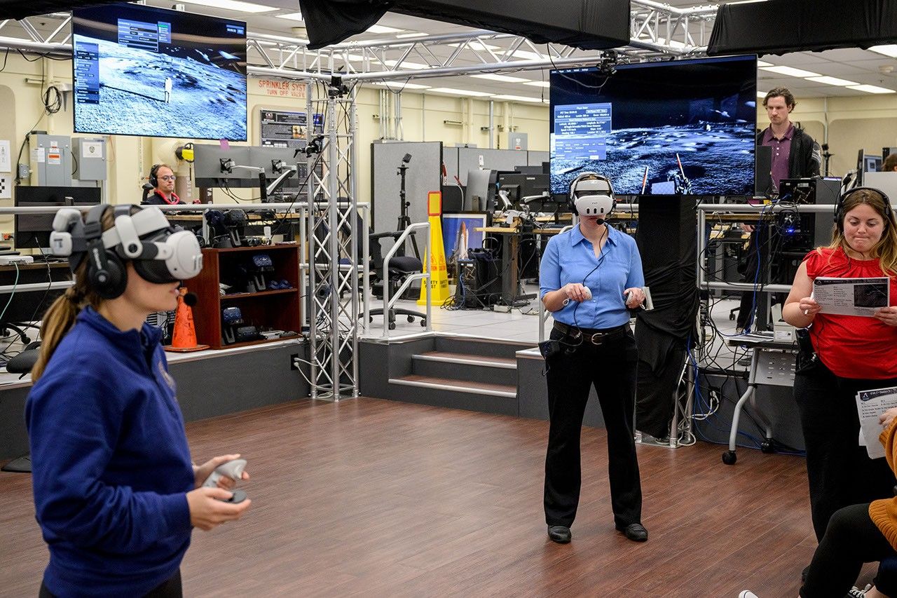 Test subject crew members for the Artemis III Virtual Reality Mini-Simulation, including Grier Wilt, left, and Tess Caswell, center, execute a moonwalk in the Prototype Immersive Technology lab at NASA’s Johnson Space Center in Houston. The simulation was a test of using VR as a training method for flight controllers and science teams’ collaboration on science-focused traverses on the lunar surface.