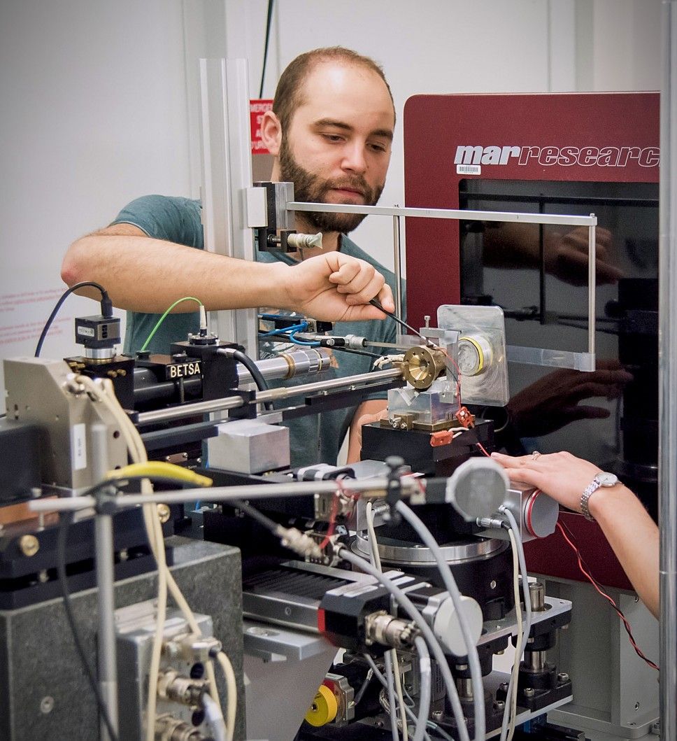 A man in a lab using a tool on some hardware.