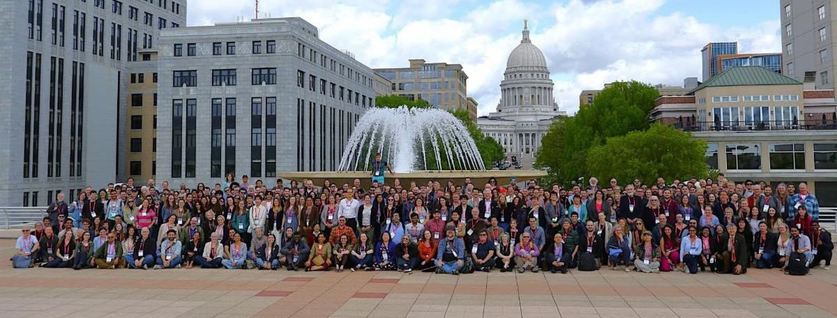 A large group of people in front of a fountain on the roof of a convention center.