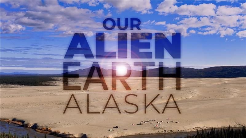 Title image for episode 5 of Our Alien Earth, depicting an aeriel view of sand dunes, with mountains looming in the background, and campsite of many tents in the foreground.