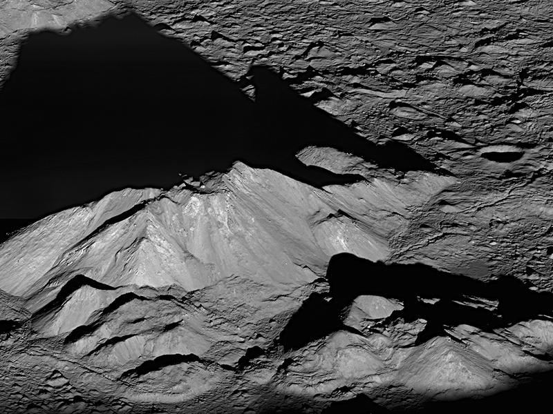 Steep, rugged mountains casting a dramatic shadow across the lunar surface.