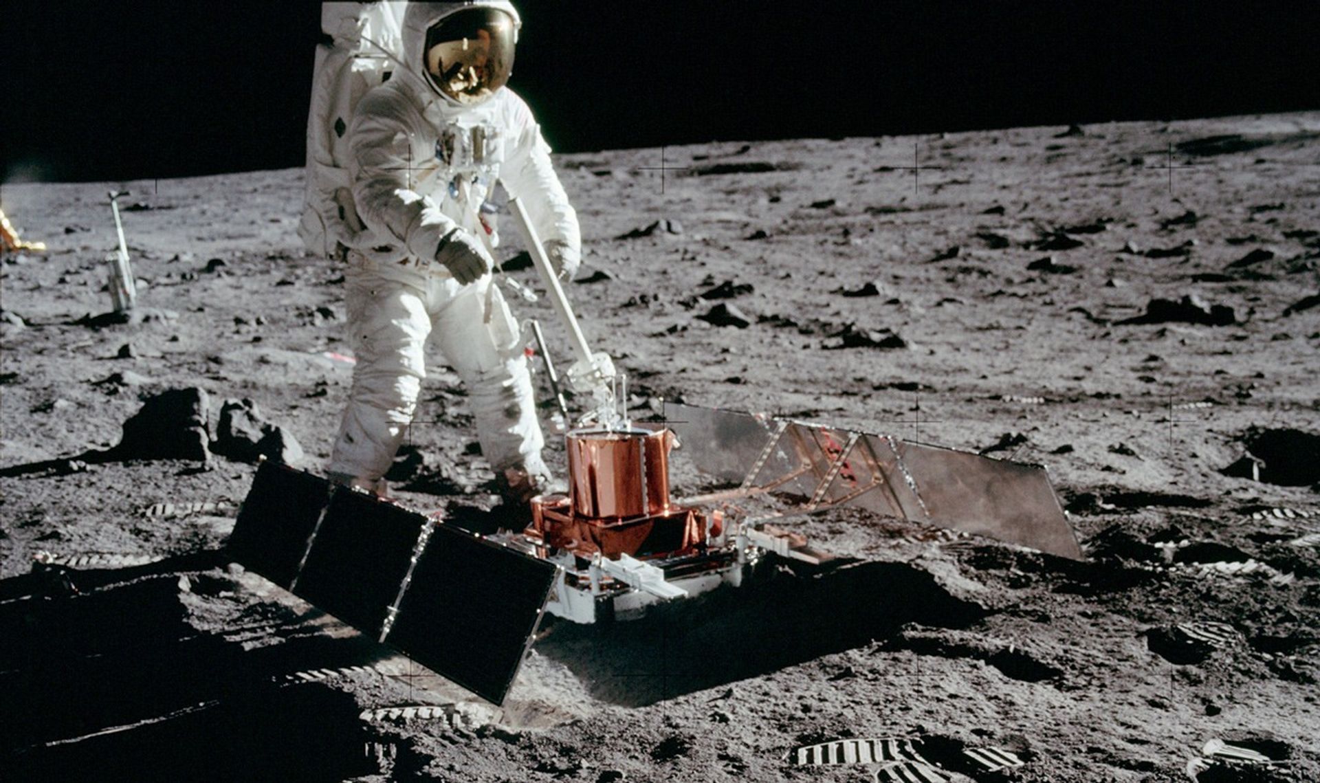 Color image of astronaut with scientific equipment on the Moon.