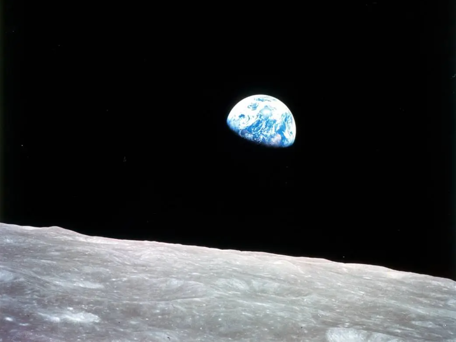 blue Earth against a black sky above the barren lunar surface