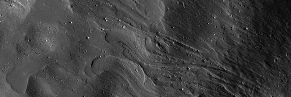 Black and white image shows now-frozen grey lobes of flow that came from the lower right. Sunlight boulders moved by the flow appear as irregular white lumps.