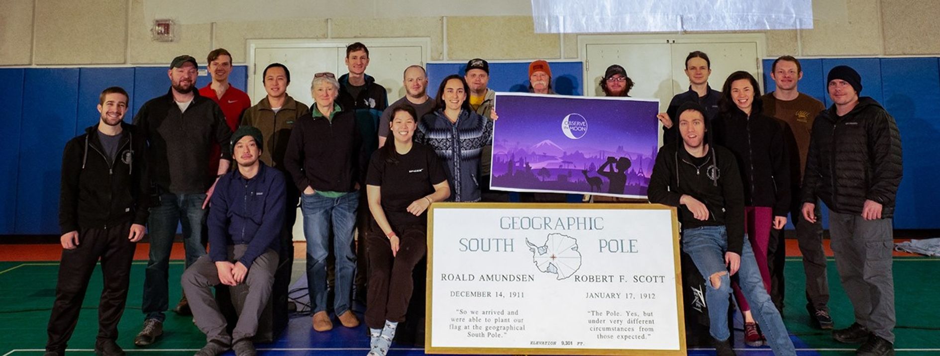 Group of people posing with a large poster.