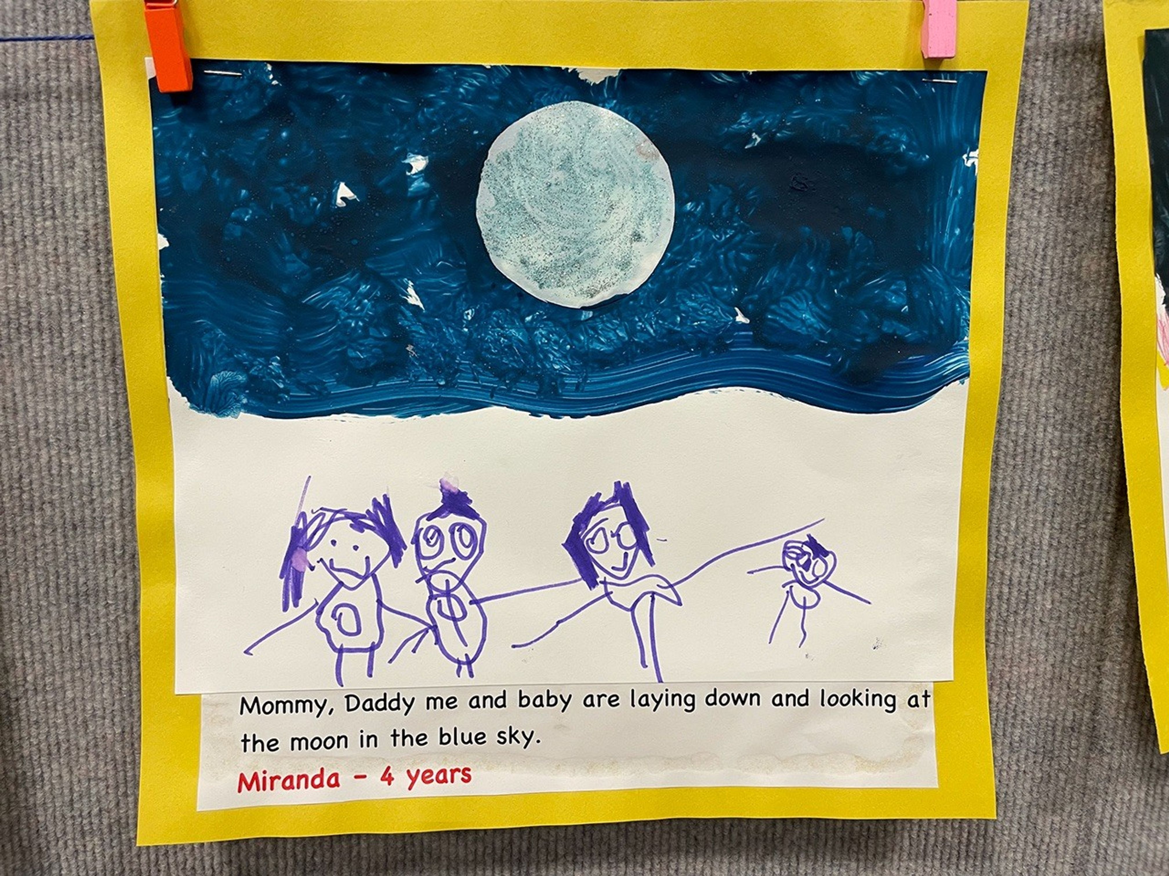 A painting of the full Moon is shown in a dark blue sky. Four stick figure people stand below the night sky.