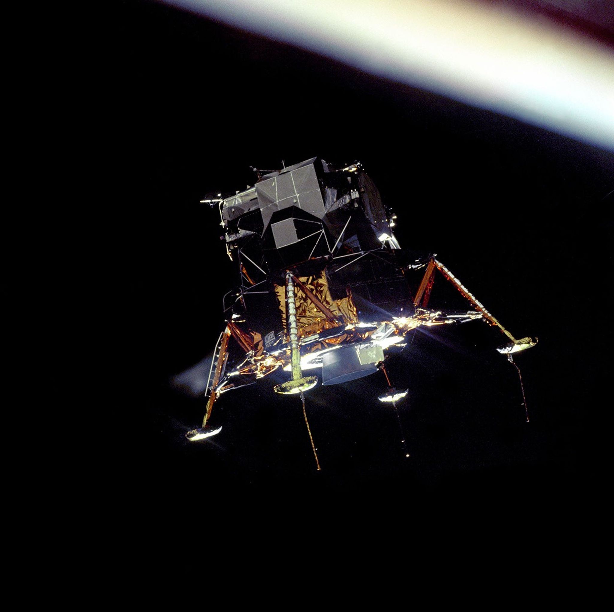 Lunar landing module suspended in a black sky.