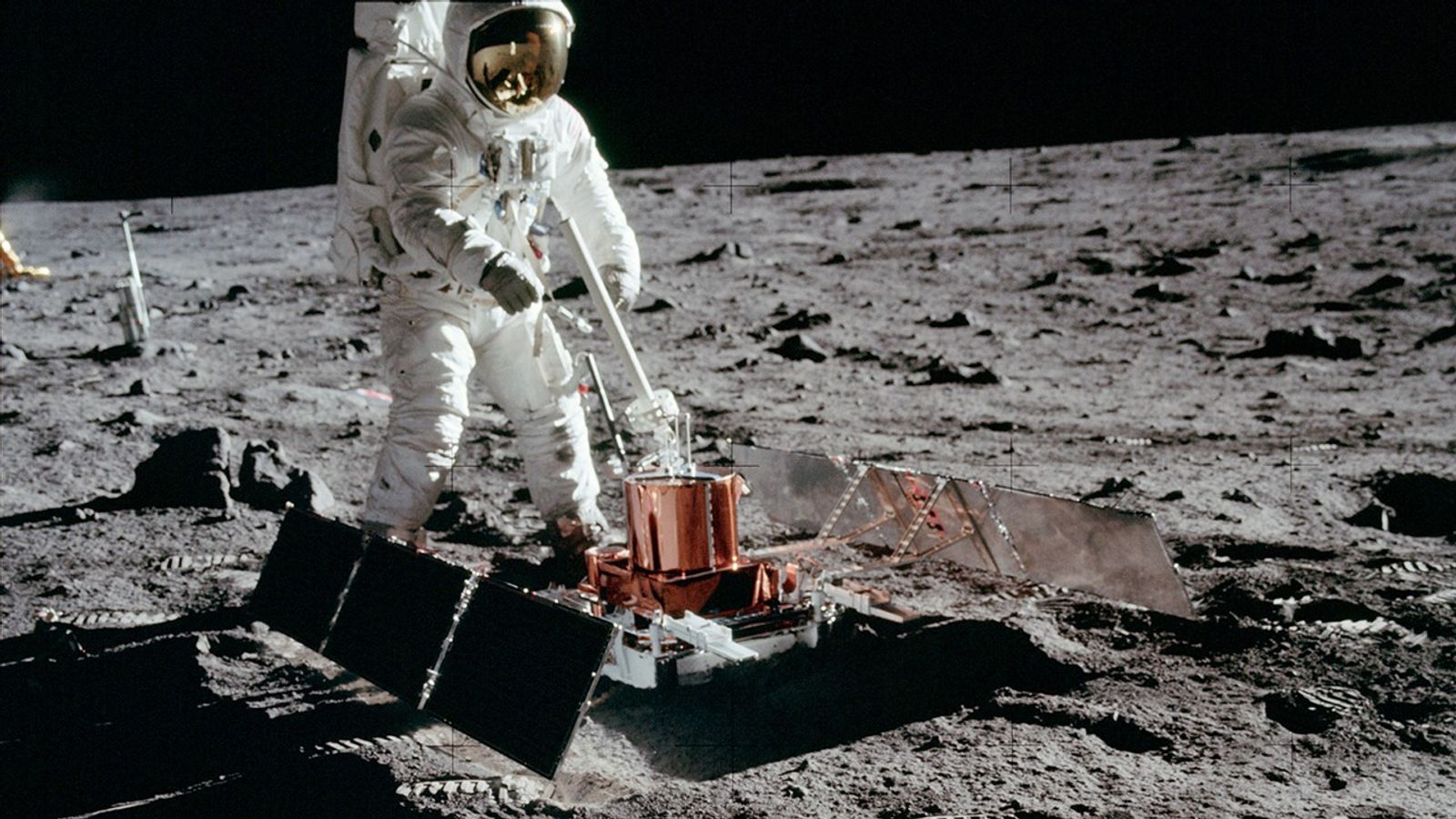 Color image of astronaut with scientific equipment on the Moon.