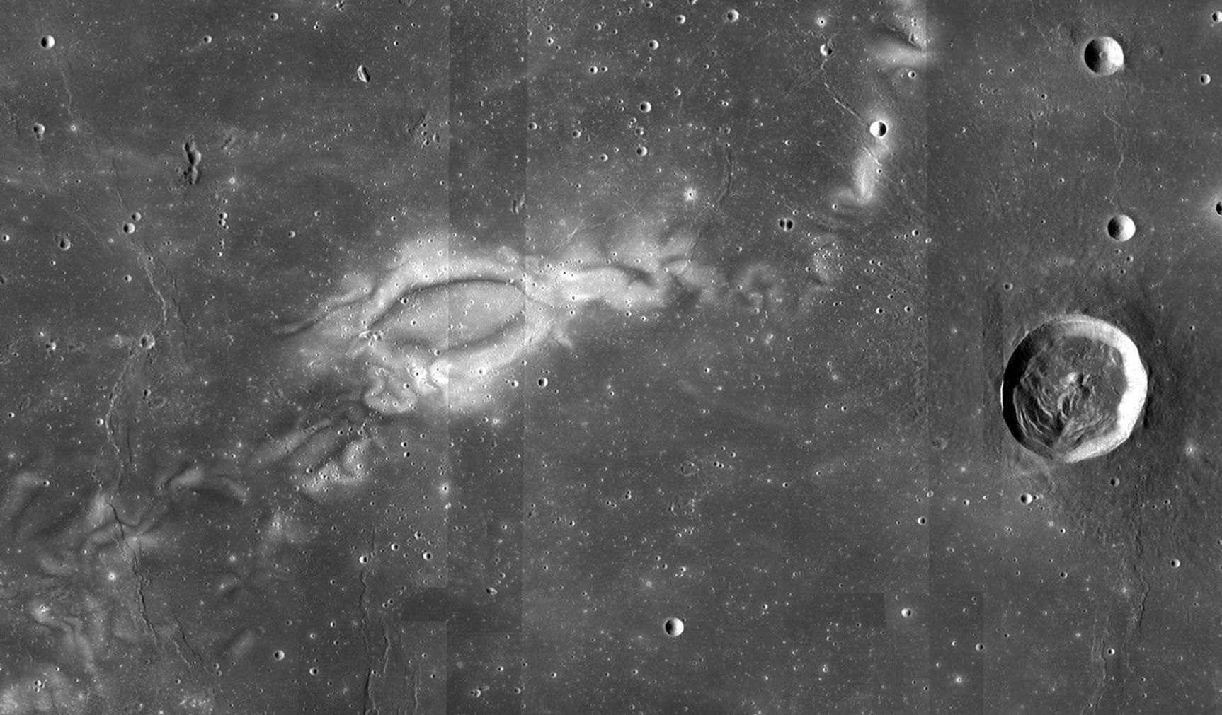 Black and white image of craters and swirls on the Moon.