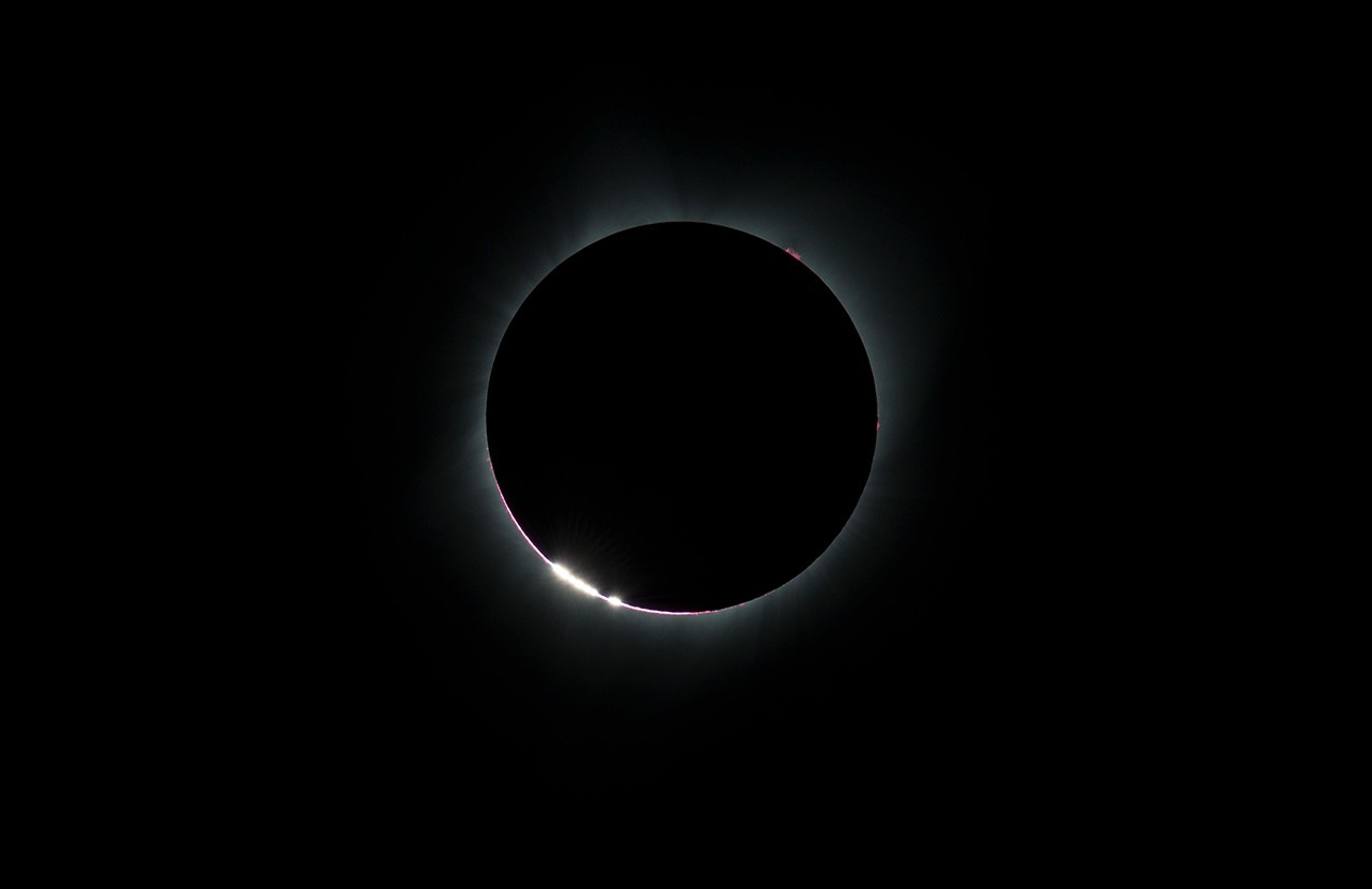 bright glowing "beads" at the edge of the Moon as the Moon nearly completely covers the Sun