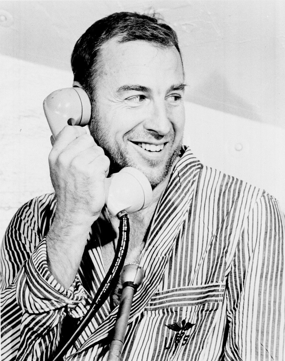 Man smiling and holding phone up to ear