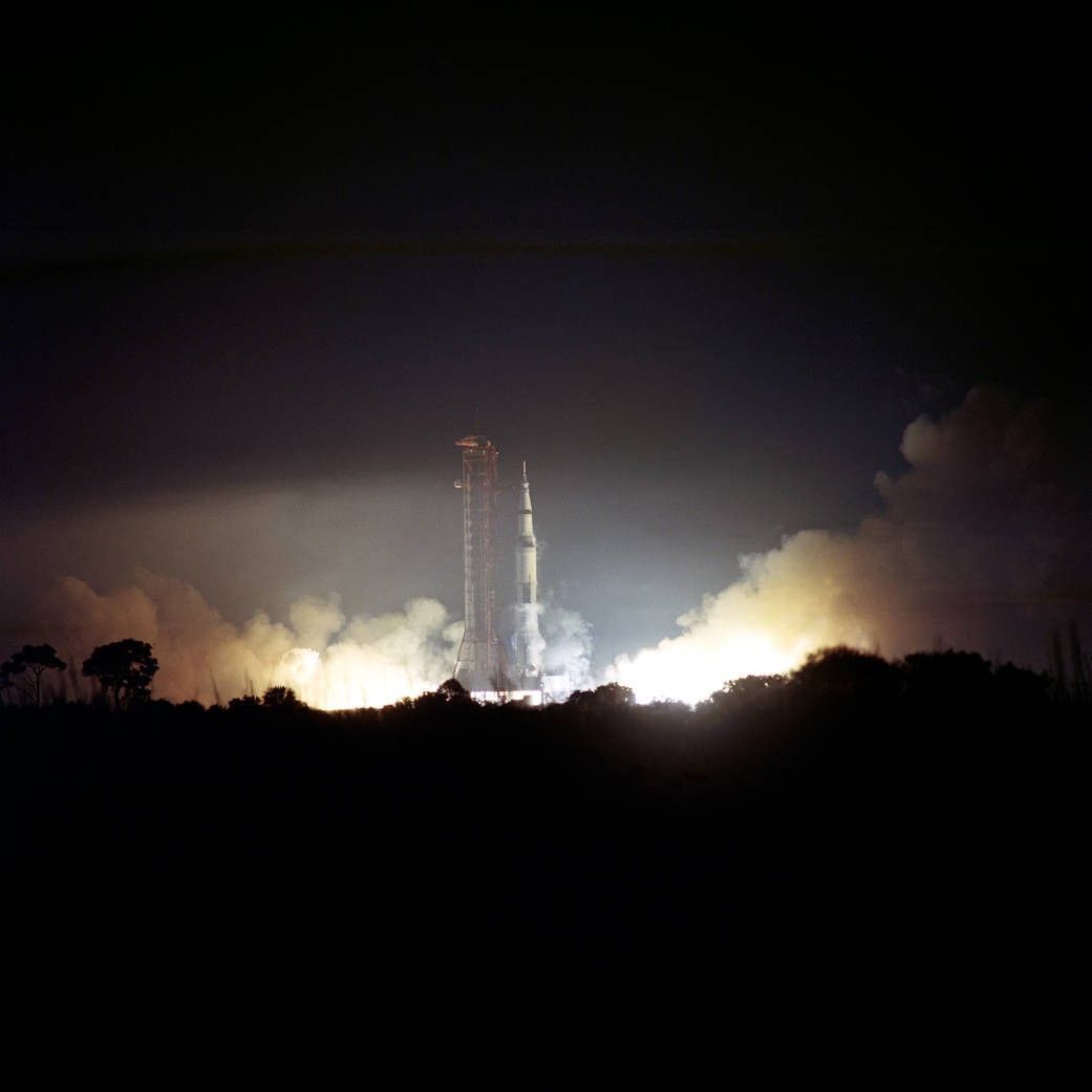 Apollo 17 launch illuminates nighttime horizon.