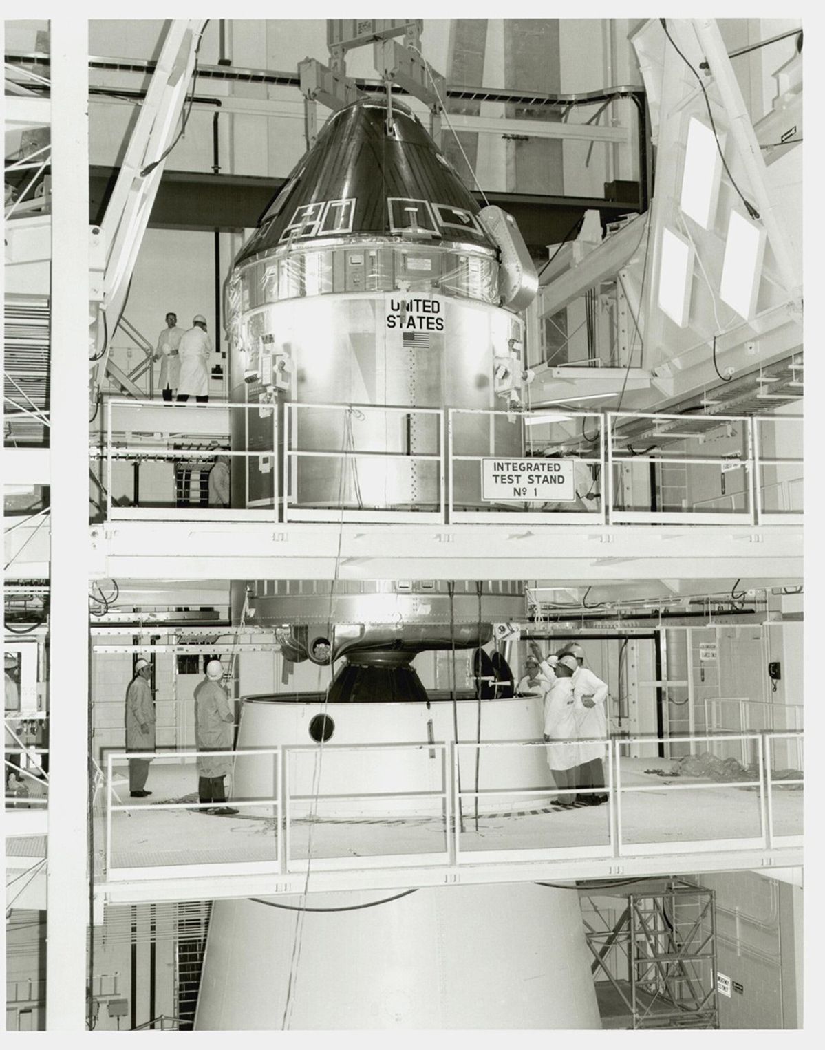 Apollo 11 Command and Service Module, taking up multiple scaffolded floors of an indoor facility, with people working on the upper two floors