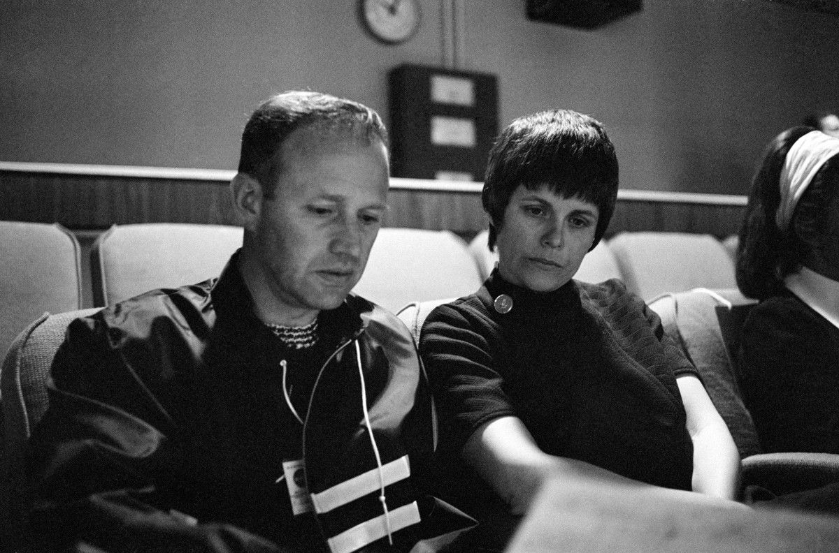 Man and woman in mission control viewing center, with concerned expressions. 
