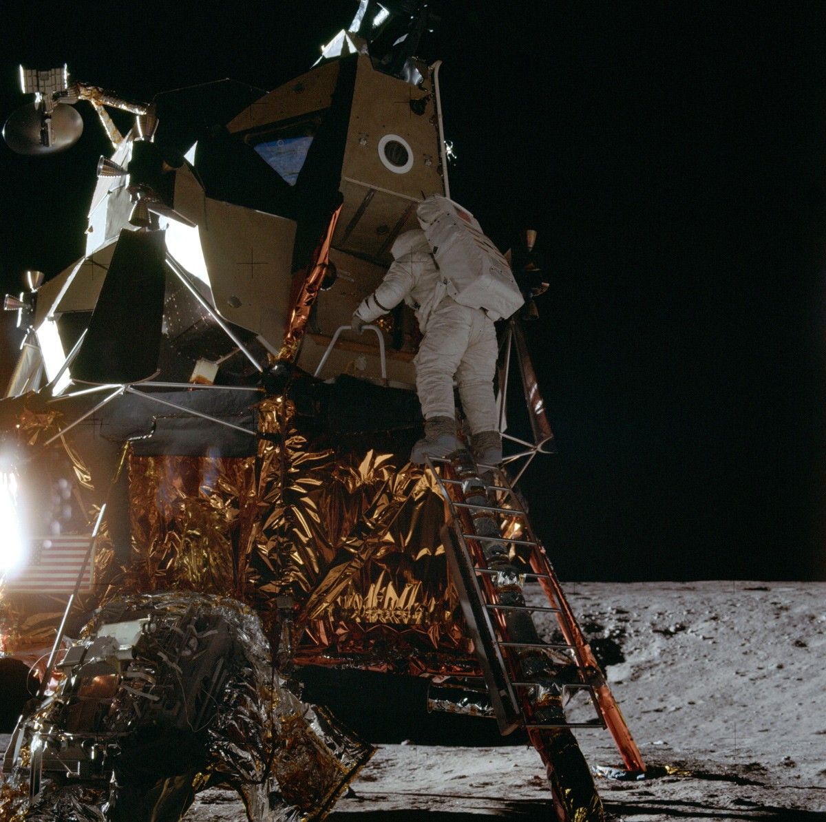 Astronaut climbing down ladder from lunar module on the Moon
