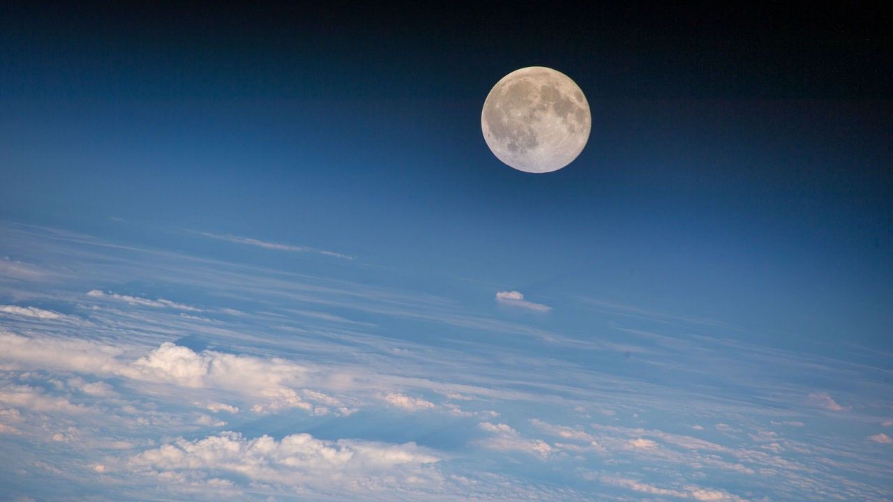 Color image of the moon above Earth's clouds.