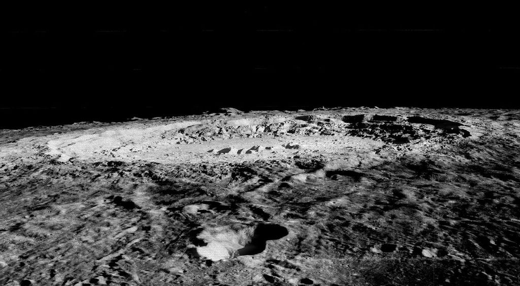 large, rugged impact crater seen nearly edge-on on the lunar horizon