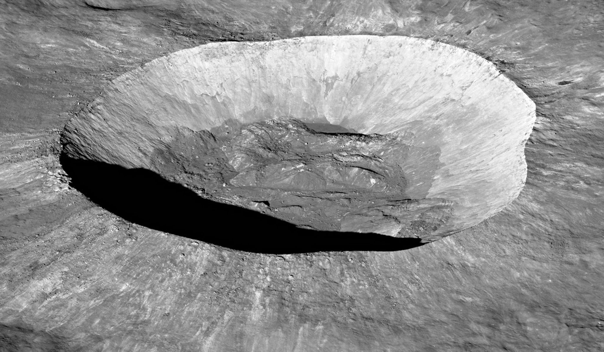 A crater with a mounded floor and ejecta streaks radiating from the center of the crater.