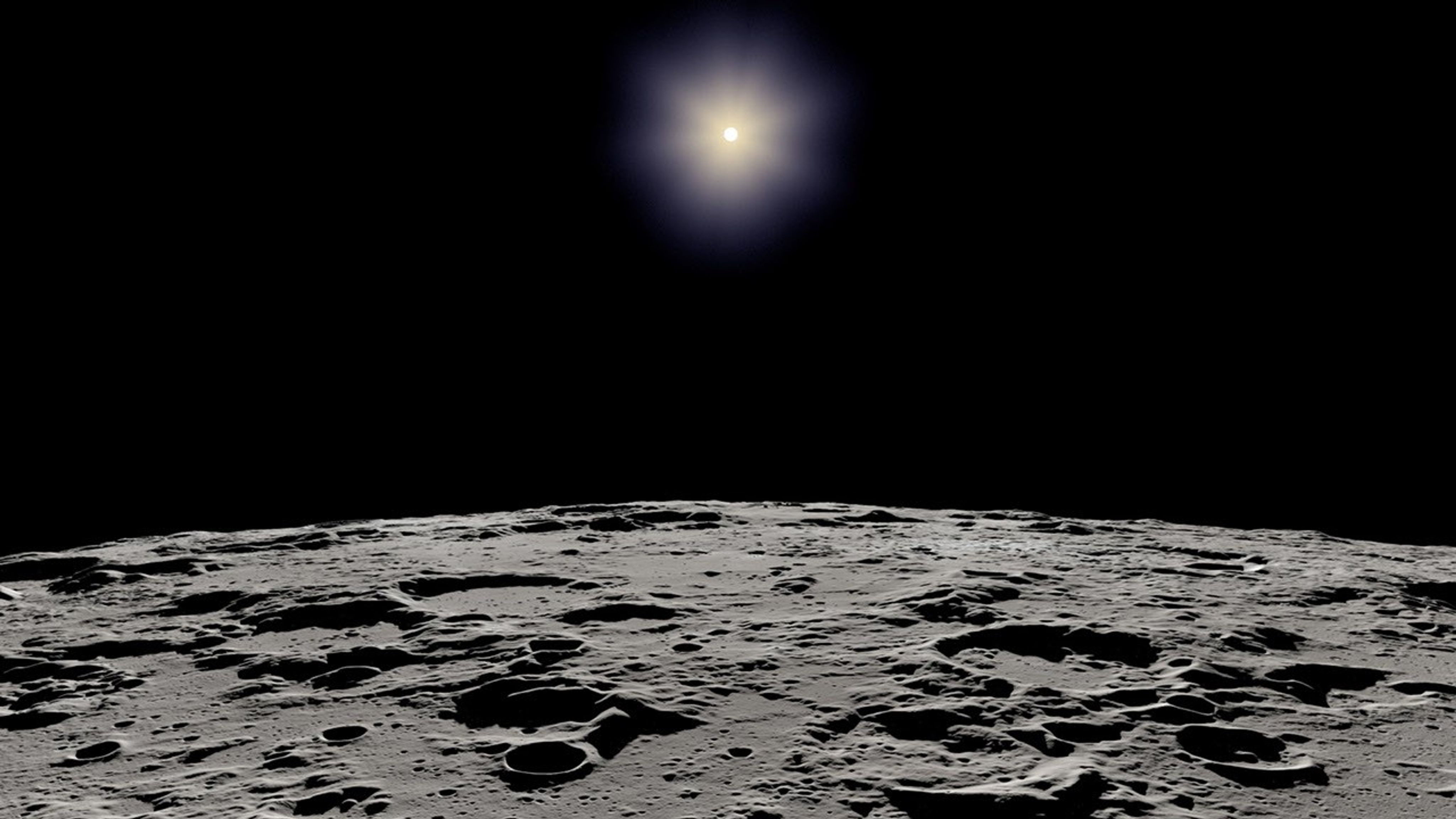 The Sun, represented as a bright white dot with a glowing white aura is high in a black sky. The bottom third of the image shows a jagged and cratered gray curved landscape – the limb of the Moon.