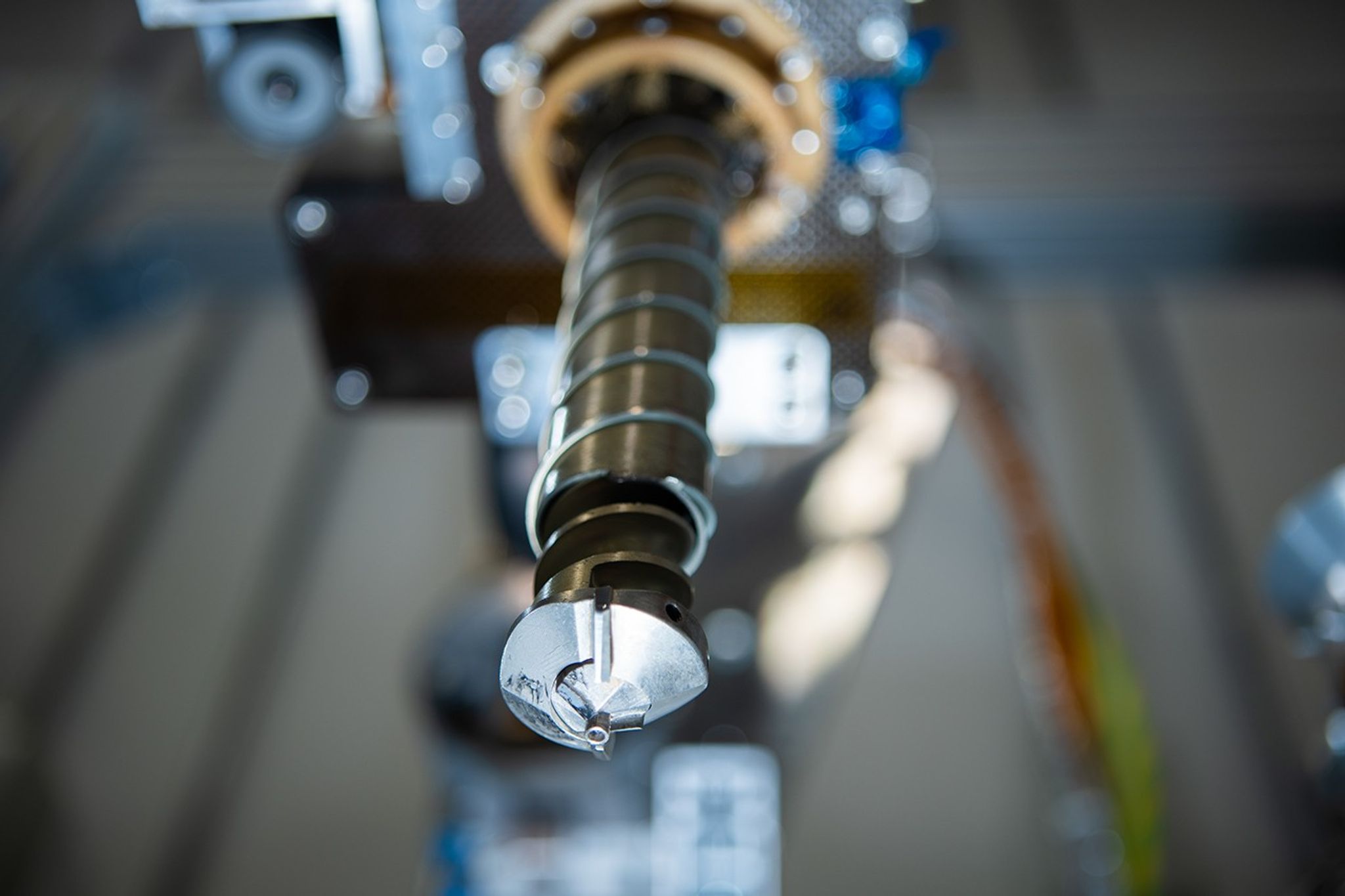 A close-up image of the Prospect drill head. There are heating coils wrapped around the drill bit.