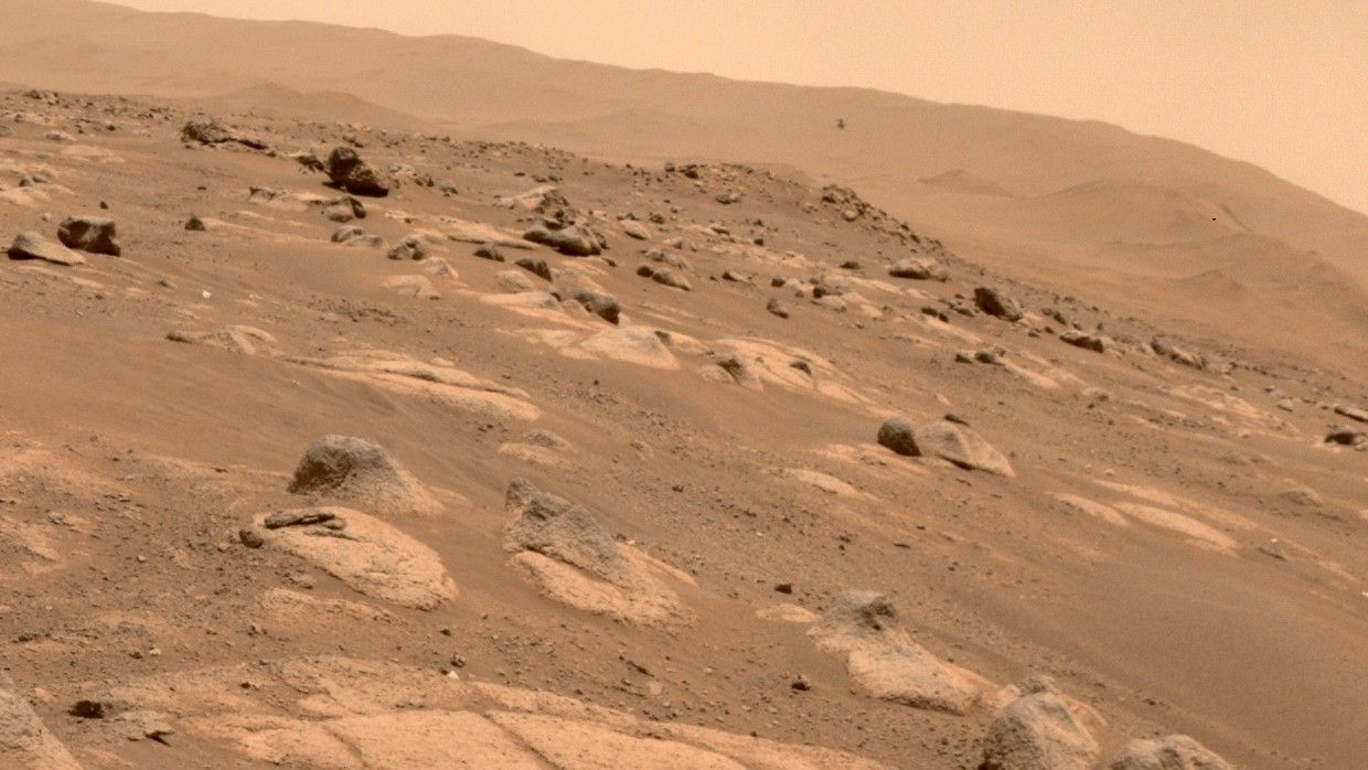 NASA’s Ingenuity Mars Helicopter (above center to the right) is viewed by one of the hazard cameras aboard the Perseverance rover during the helicopter’s fourth flight on April 30, 2021.
