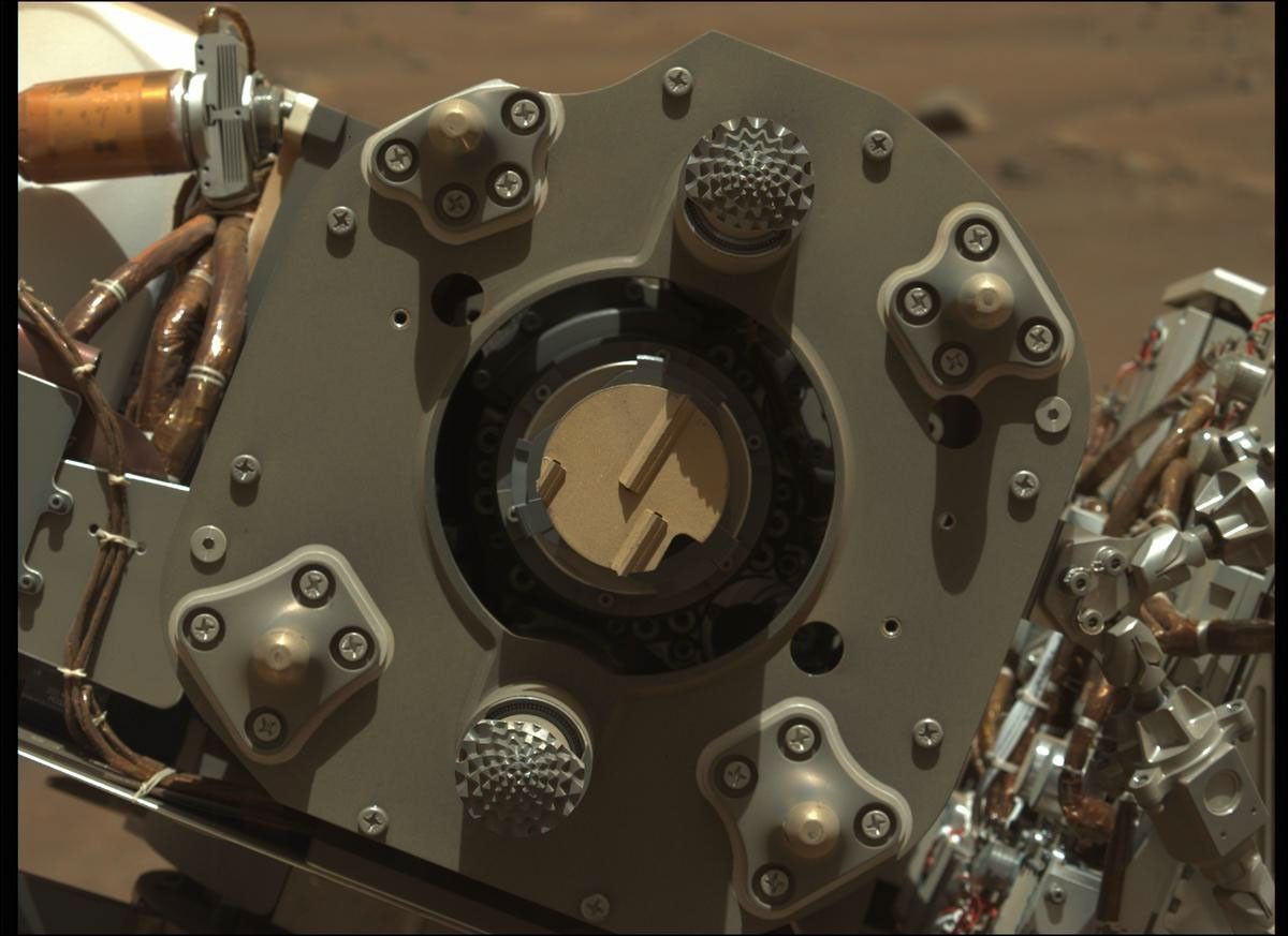 Close-up  photo of Perseverance rover's drill, with its abrading bit facing the camera. The bit has a flat surface, 5 centimeters in diameter, with linear teeth for grinding rocks.