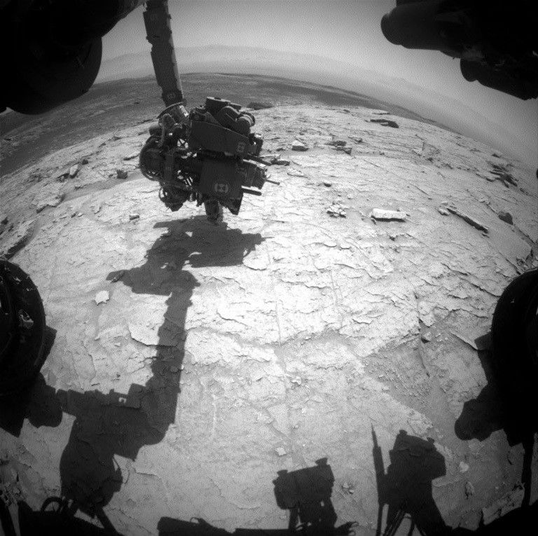 Parts of the rover are visible in this view of Mars