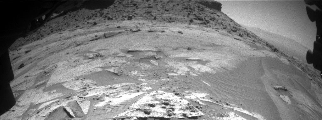 The triangular shaped rock in the immediate foreground contains the crushed nodule targets “Helmsdale Boulder Beds” and the “Crovie” bedrock target. In the background, the slope is covered with grey float blocks similar to those being imaged by Mastcam. The pediment-capping rock is at the top of the image, just right of centre.