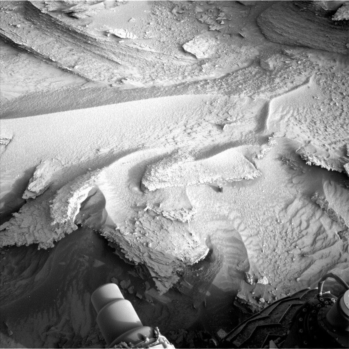 This image of ripples in the sandy Mars terrain and part of Curiosity visible was taken by the Curiosity rover on Sol 3810.