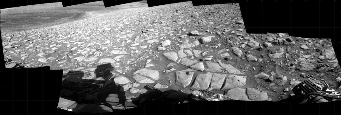 A Curiosity rover's navcam mosaic of the current workspace and drive direction with the area of light and dark bands.