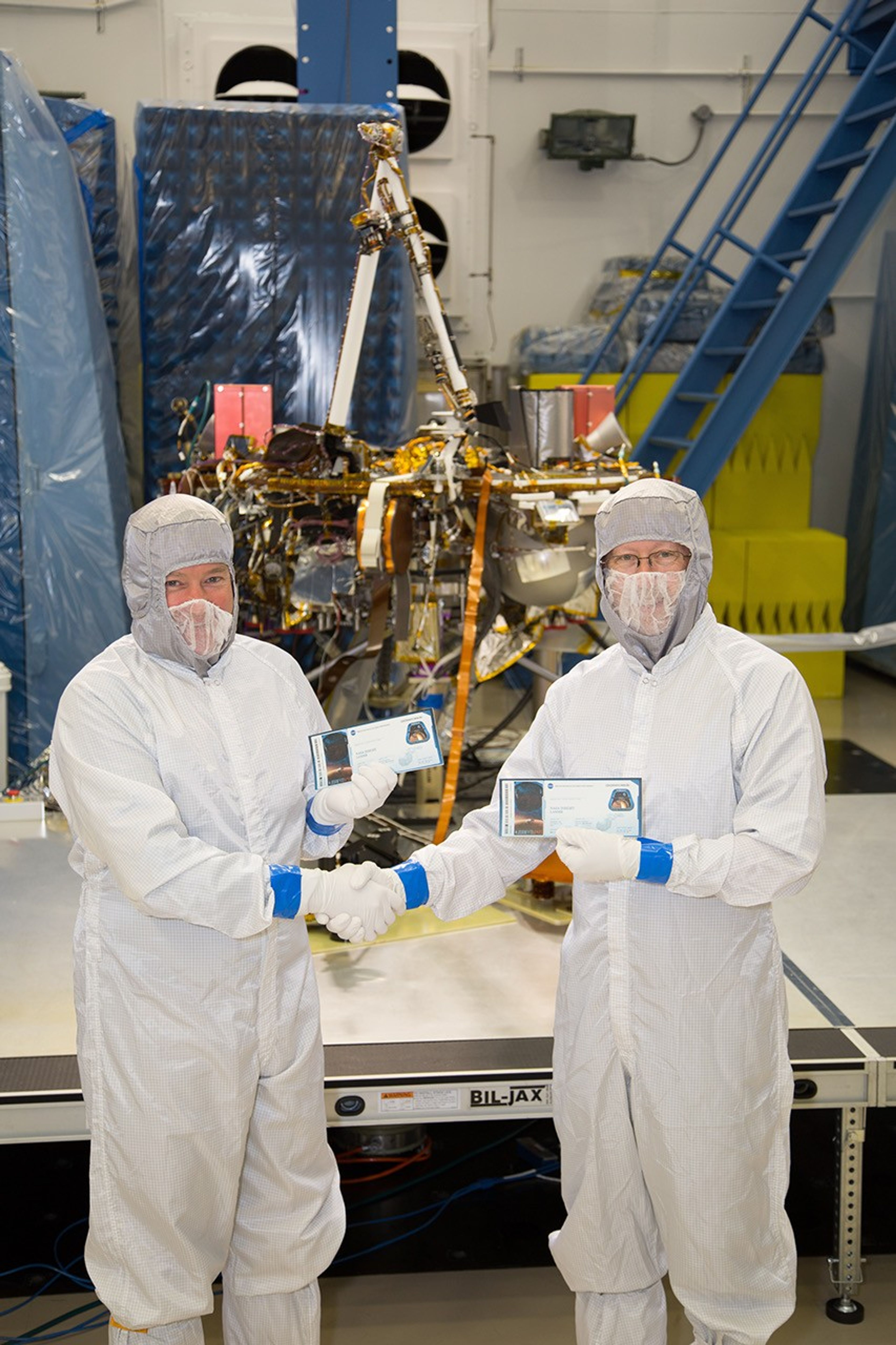 InSight project manager Tom Hoffman and principal investigator Bruce Banerdt pose with their "boarding passes" in 2015, showing that they're both sending their names to Mars.