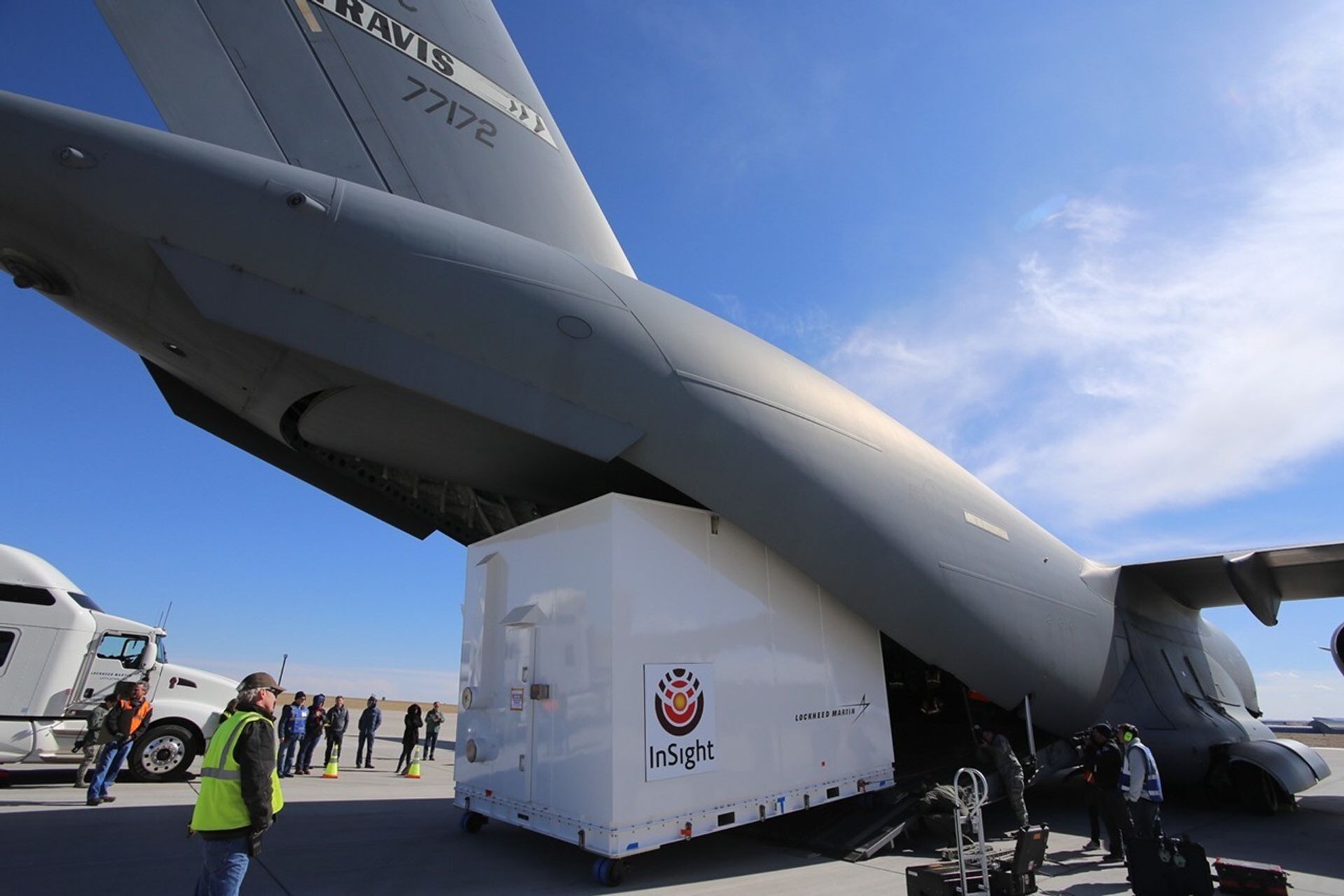 large crate being loaded into military transport plane