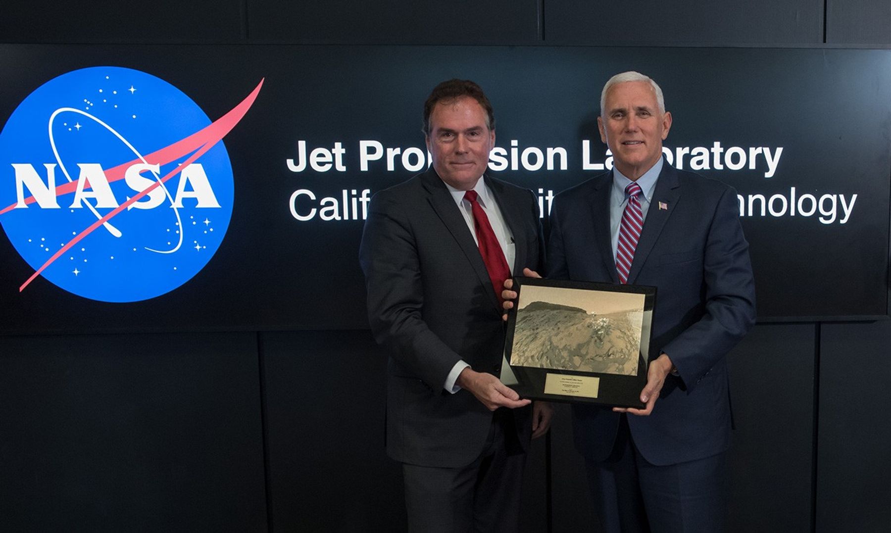 U.S. Vice President Mike Pence, right, is presented a plaque by JPL Director Michael Watkins during a tour of NASA's Jet Propulsion Laboratory, Saturday, April 28, 2018 in Pasadena, California. The plaque presents a view of the Mars Science Laboratory rover Curiosity on the surface of Mars.