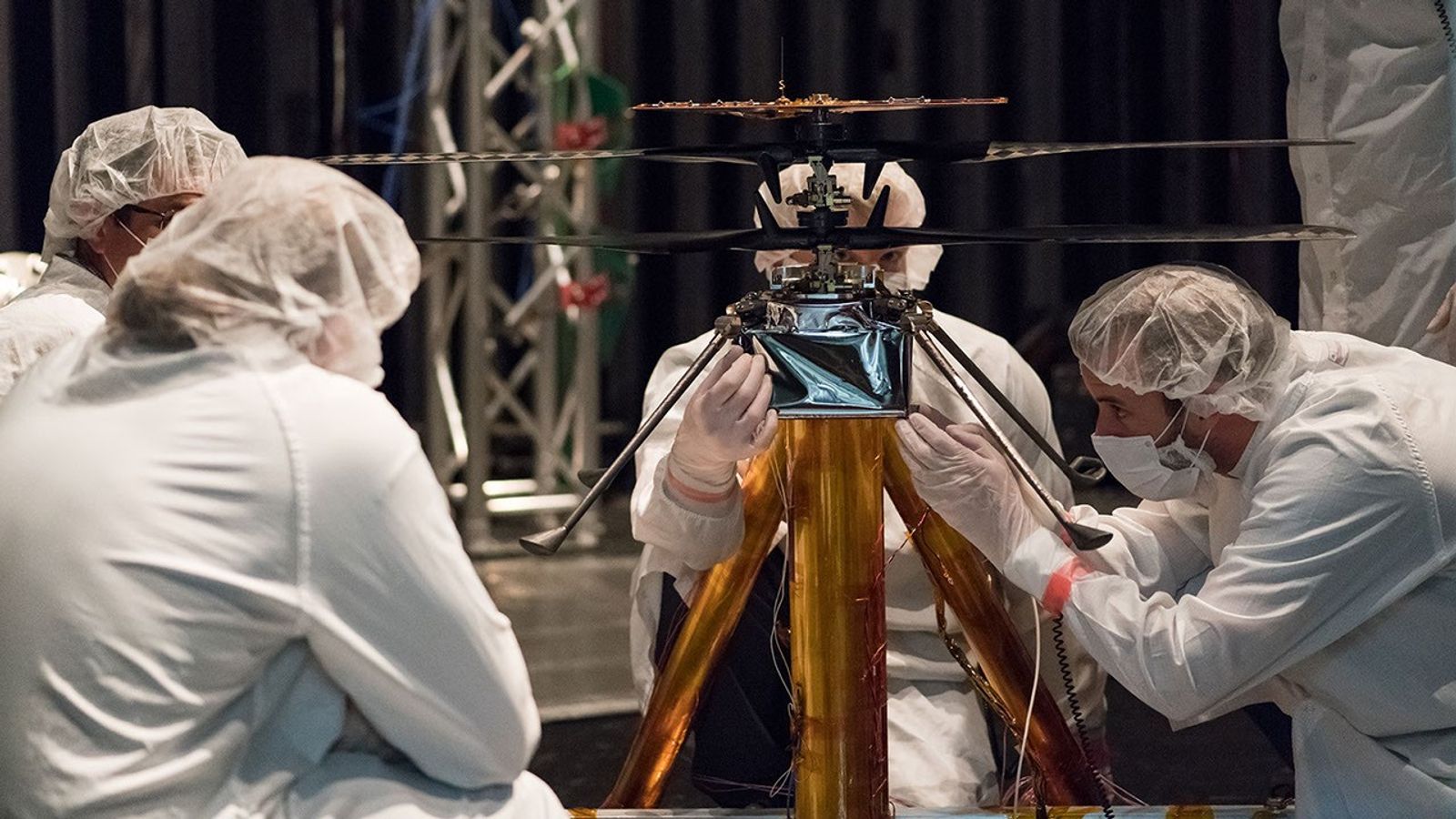 NASA Mars Helicopter team members work the flight model (the vehicle going to Mars) in the Space Simulator.
