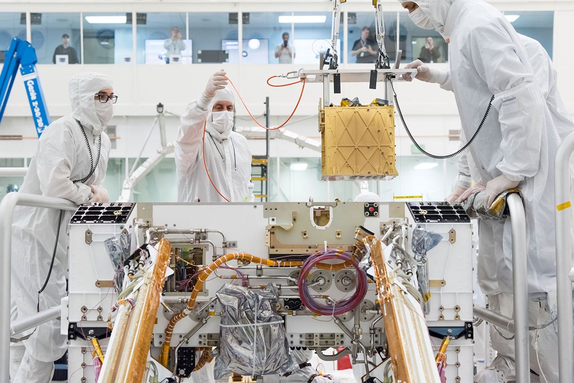 Mars 2020 engineers install the Mars Oxygen In-Situ Resource Utilization Experiment (MOXIE) into the chassis of the rover.