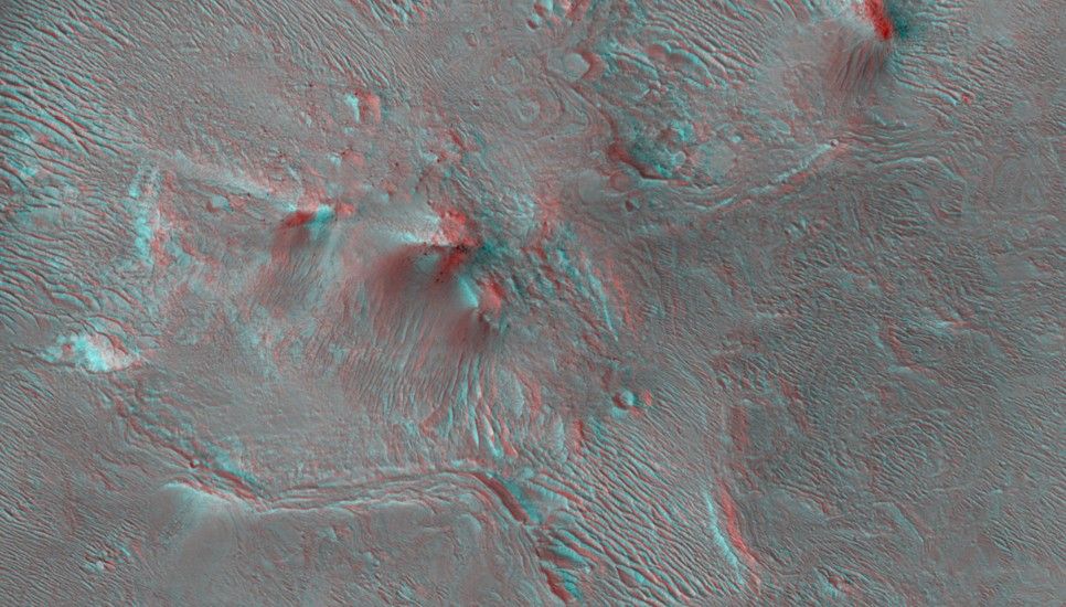 An image of the transitional terrain where the linear troughs and rounded pits of an area called "Noctis Labyrinthus" merge with the larger canyon of "Valles Marineris."