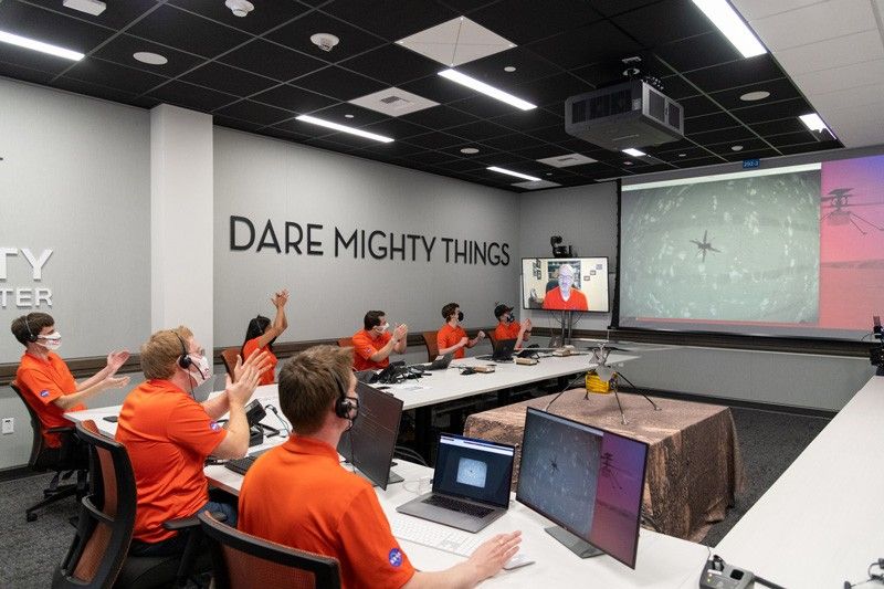 Members of NASA’s Ingenuity helicopter team react to data showing that the helicopter completed its first flight