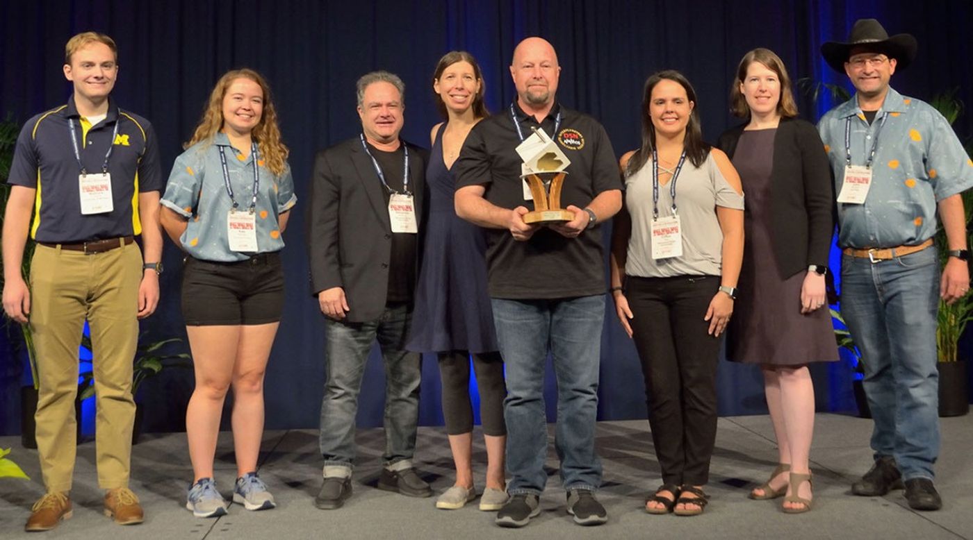 JPL engineer Glen Elliott (center) holds the 2019 Small Satellite Mission of the Year Award alongside others who supported the MarCO mission. Left to right: Matthew Szczerba, Kate Parkinson, Ben Malphrus, Kerri Cahoy, Glen Elliott, Chloe Hart, Emily Clements and John Belardo.