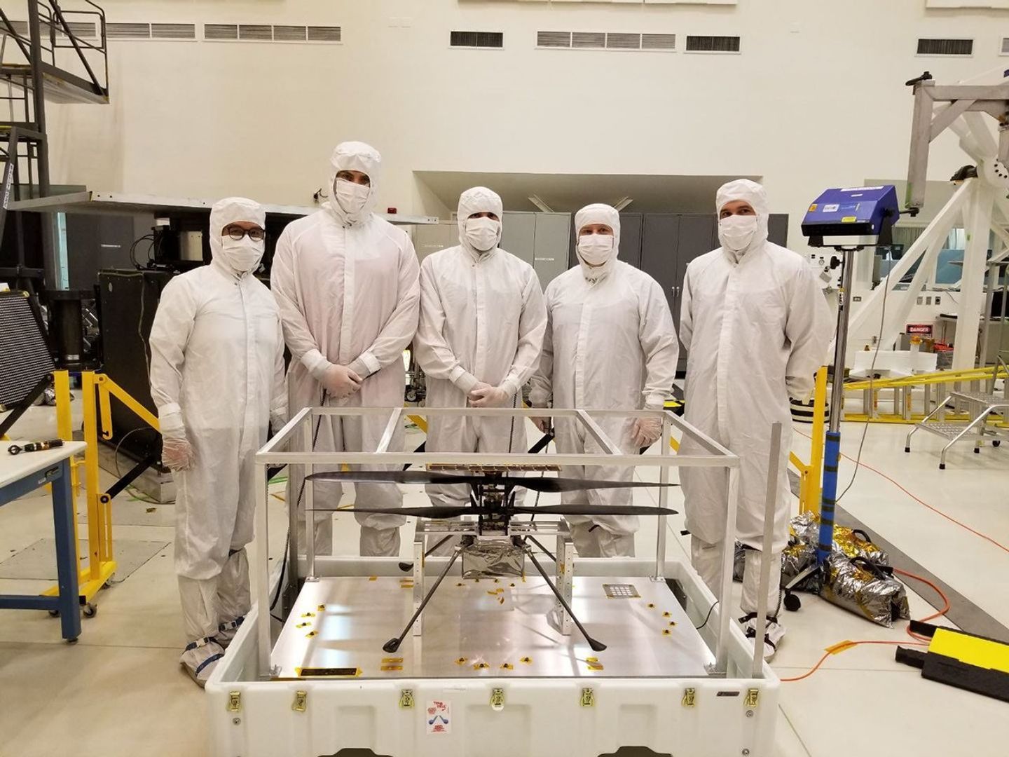 Members from NASA's Mars Helicopter and Mars 2020 teams stand behind the Mars Helicopter.