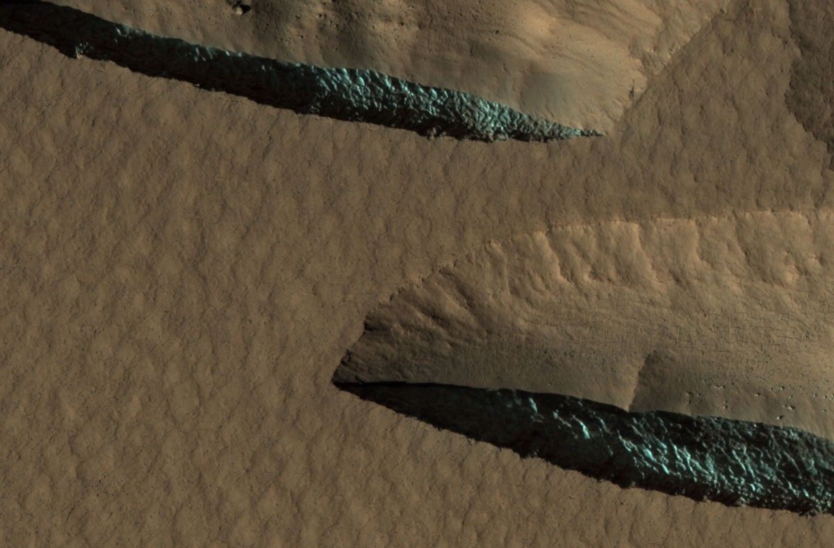 There are steep scarps facing the poles of both hemispheres that expose thick (up to 100 meters or more) sections of nearly pure water ice.