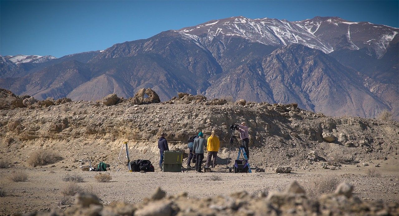 A field team sets up equipment in a dry lakebed in the Nevada