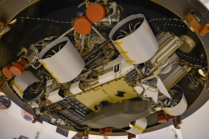 Seen from below, NASA's Mars 2020 Perseverance rover bears a plaque to the right of its middle wheel.